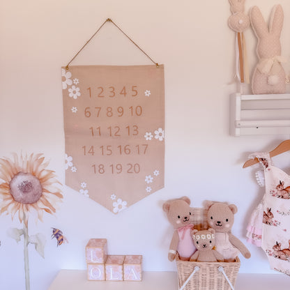 Children's room with teddy bears, number banner, and floral decorations.