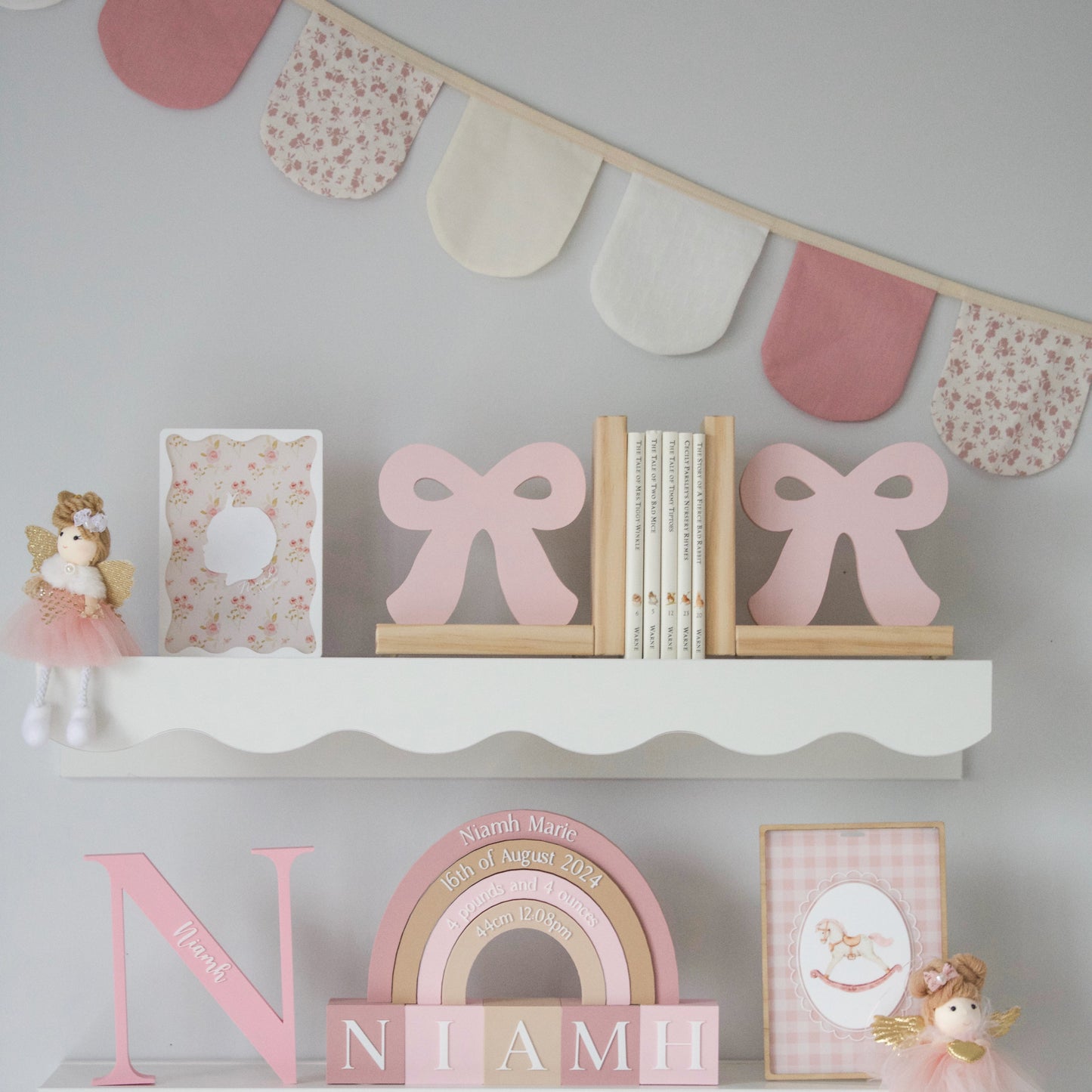 Decorative shelves with pink and white fabric bunting.
